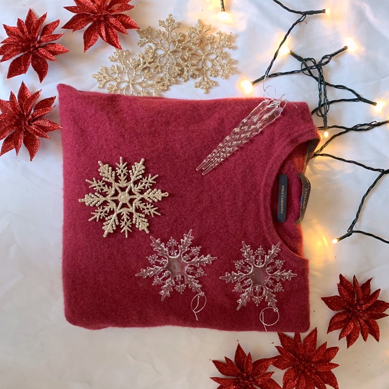 Luxury cashmere sweater styled with Christmas decor — cozy holiday vibes